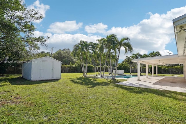 view of yard featuring a fenced in pool, a patio, a fenced backyard, a storage unit, and an outdoor structure