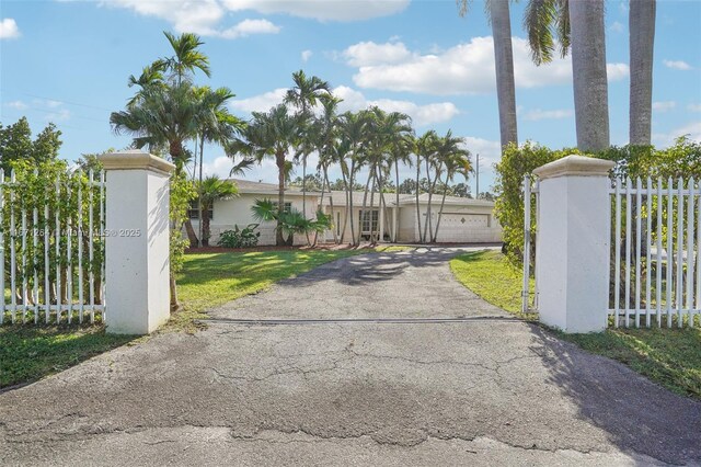 view of gate with a garage and a yard