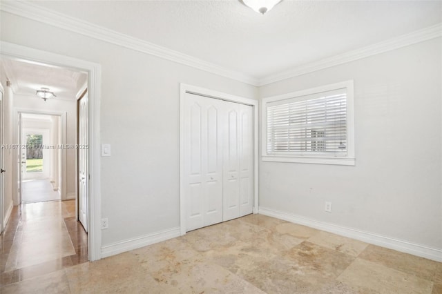 unfurnished bedroom with ornamental molding, a closet, and baseboards