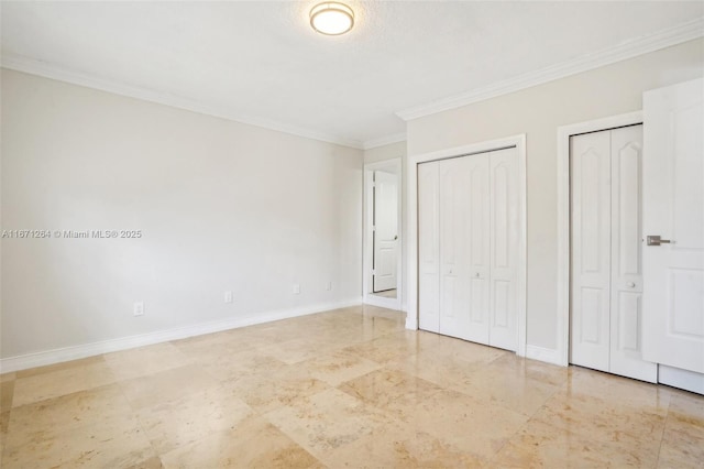 unfurnished bedroom with baseboards, two closets, and ornamental molding