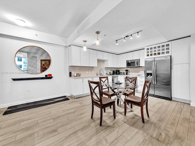 dining area with sink and light wood-type flooring