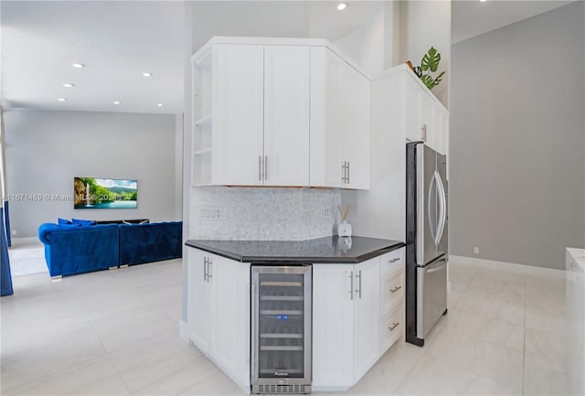 kitchen featuring backsplash, wine cooler, white cabinetry, and stainless steel fridge