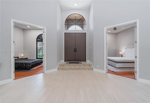 entryway with light hardwood / wood-style floors and a high ceiling