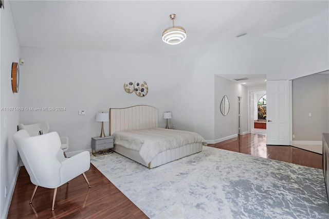 bedroom with vaulted ceiling and hardwood / wood-style flooring