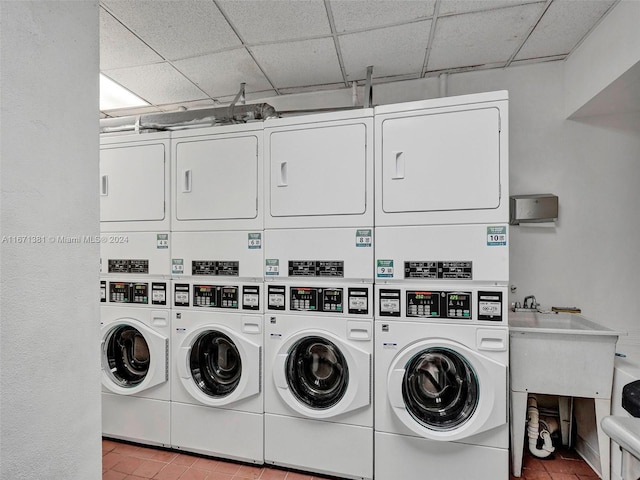 laundry area with washer and clothes dryer, sink, light tile patterned floors, and stacked washer and clothes dryer