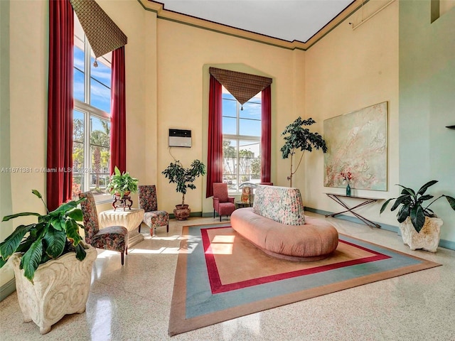 sitting room with ornamental molding and a towering ceiling