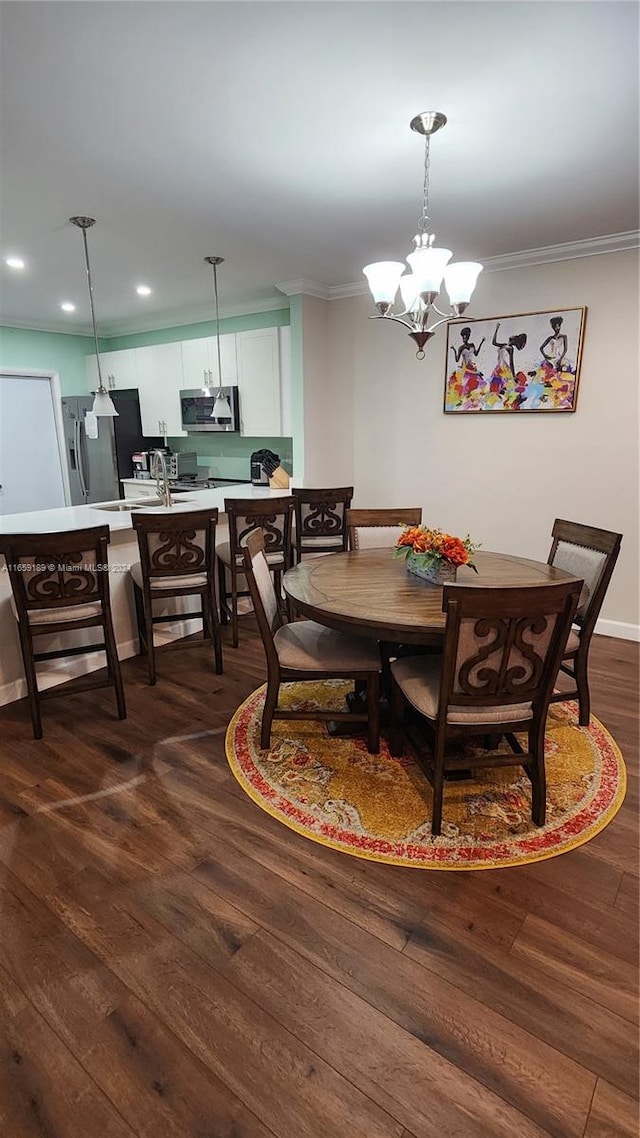 dining room with a notable chandelier, dark wood-type flooring, and crown molding