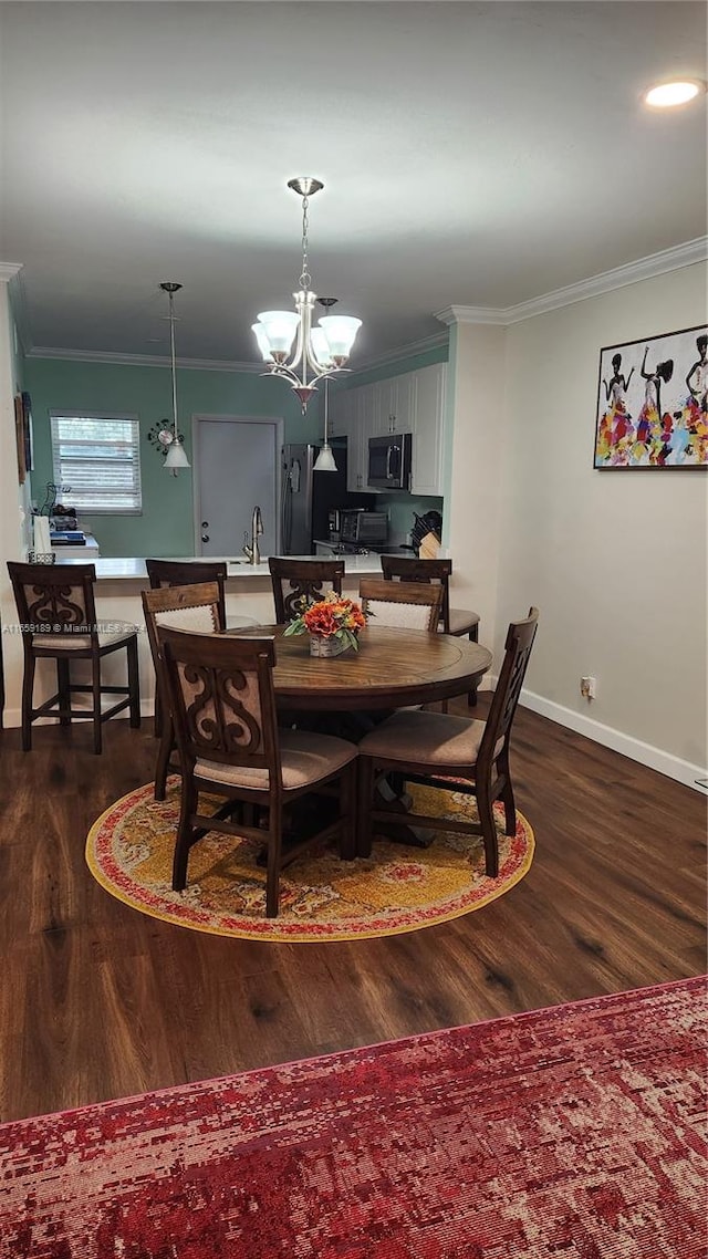 dining area with an inviting chandelier, dark hardwood / wood-style floors, ornamental molding, and sink