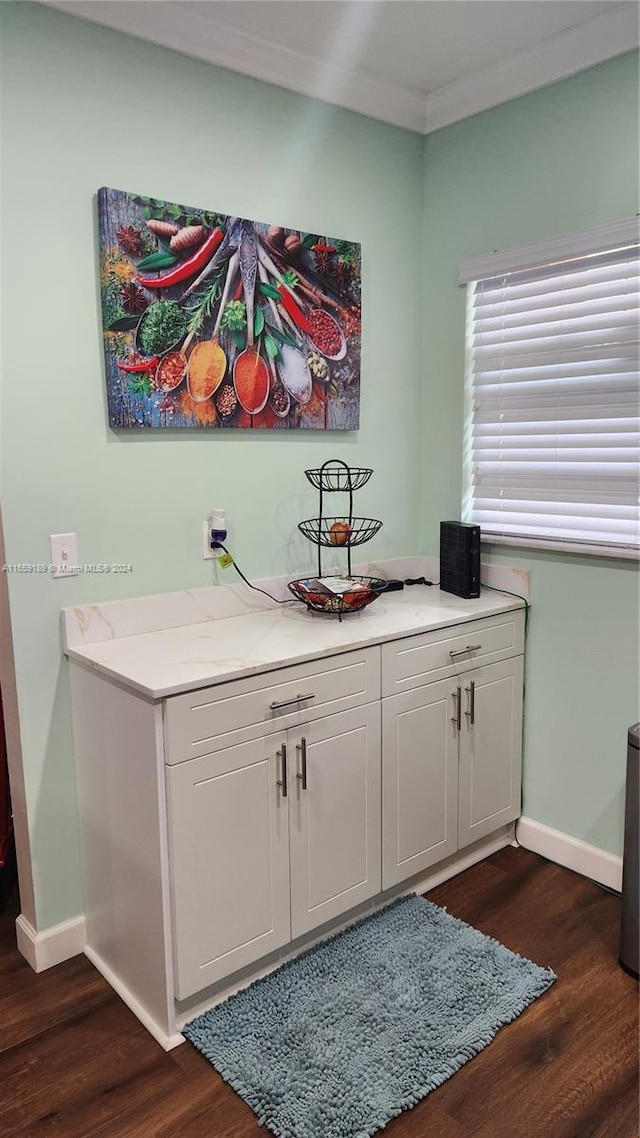 interior space with ornamental molding, dark hardwood / wood-style flooring, and white cabinetry