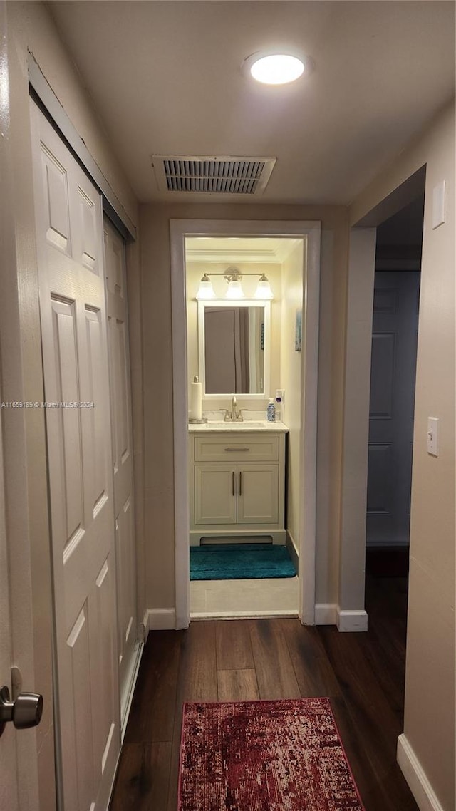 hallway featuring sink and dark wood-type flooring