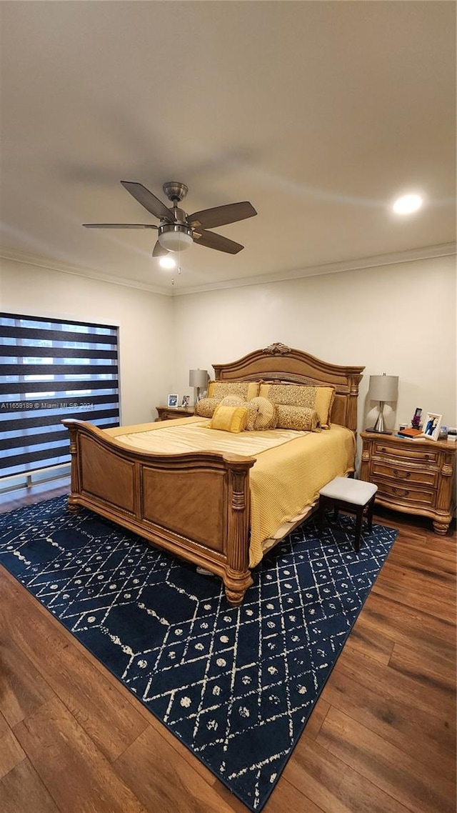 bedroom with ornamental molding, wood-type flooring, and ceiling fan