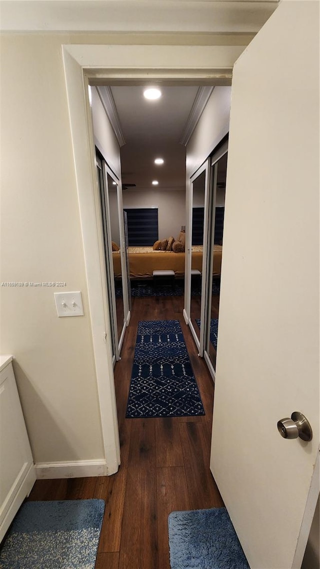 hallway featuring dark wood-type flooring and crown molding