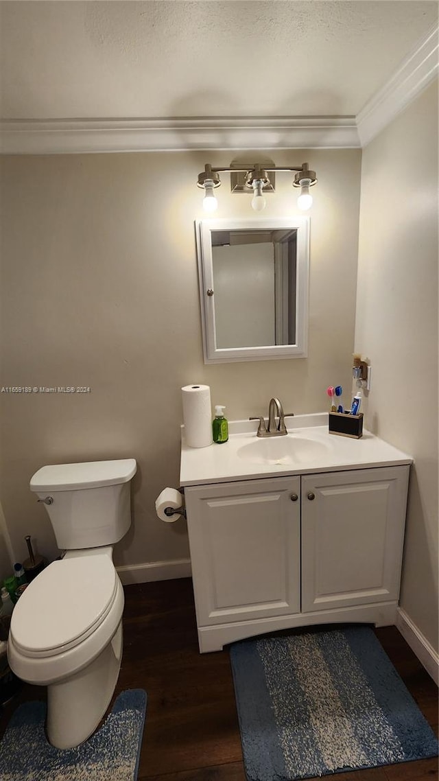 bathroom featuring ornamental molding, hardwood / wood-style flooring, vanity, and toilet