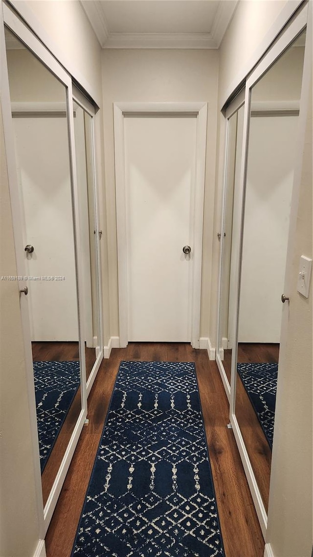 hall featuring ornamental molding and dark wood-type flooring