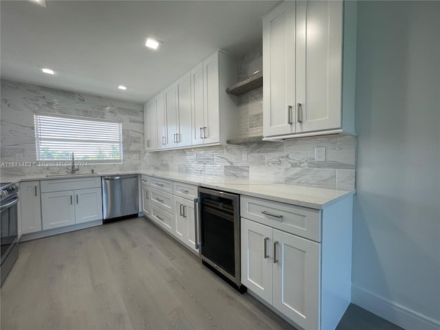 kitchen featuring stainless steel dishwasher, wine cooler, and white cabinets