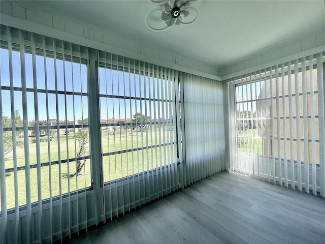 unfurnished sunroom featuring ceiling fan