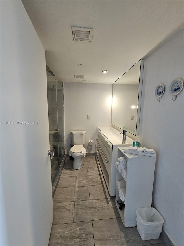 bathroom with toilet, an enclosed shower, and vanity