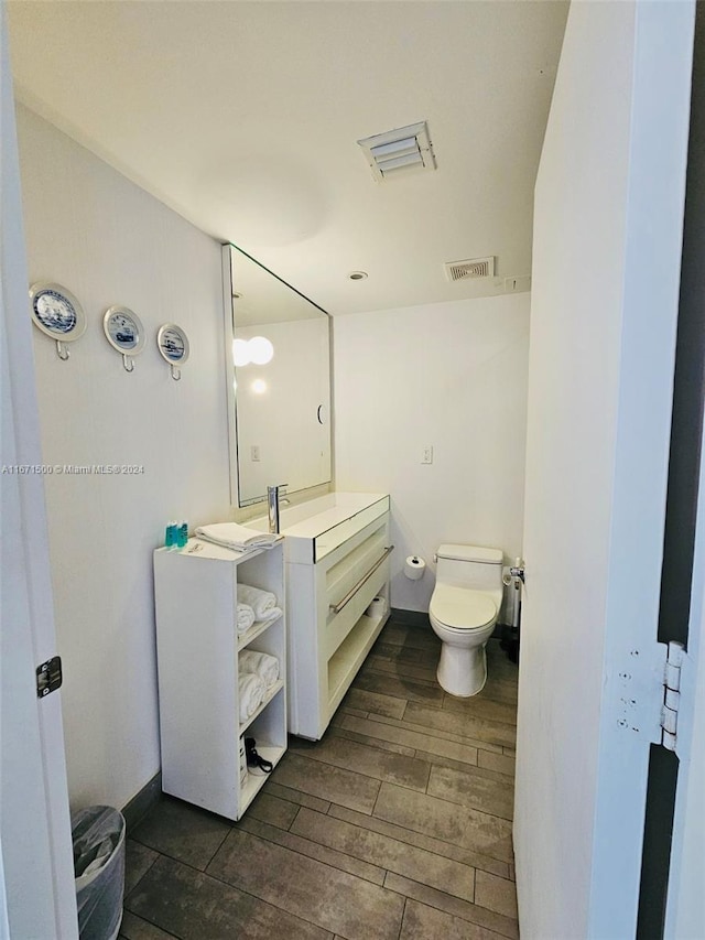 bathroom featuring hardwood / wood-style floors, vanity, and toilet