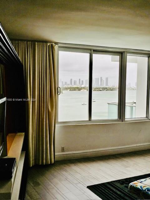 unfurnished room featuring hardwood / wood-style flooring and a water view