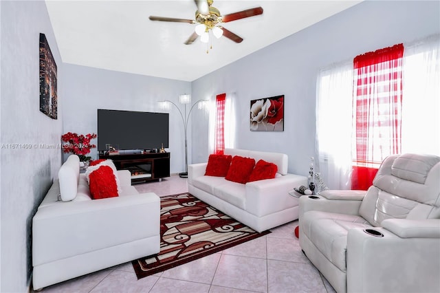 tiled living room featuring ceiling fan and a fireplace