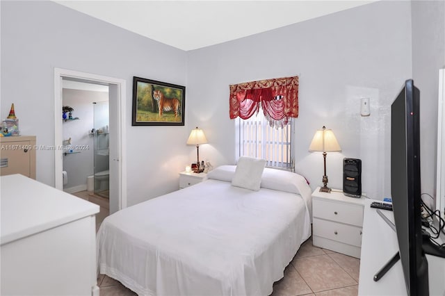 bedroom with connected bathroom and light tile patterned floors