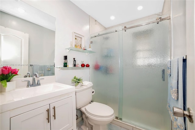 bathroom with vanity, a shower with shower door, toilet, and tile patterned floors