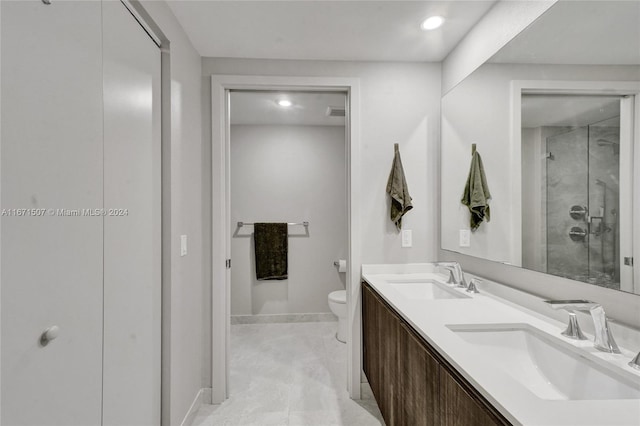 bathroom with toilet, vanity, and a shower with door