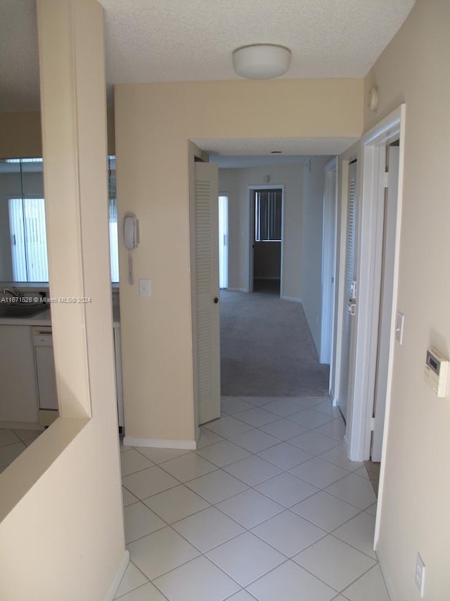 9511 Weldon Cir Unit G402, Tamarac, FL 33321 - hall featuring baseboards, light tile patterned floors, and light colored carpet