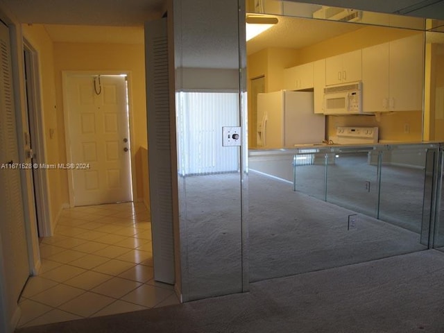 kitchen with white appliances and light tile patterned flooring