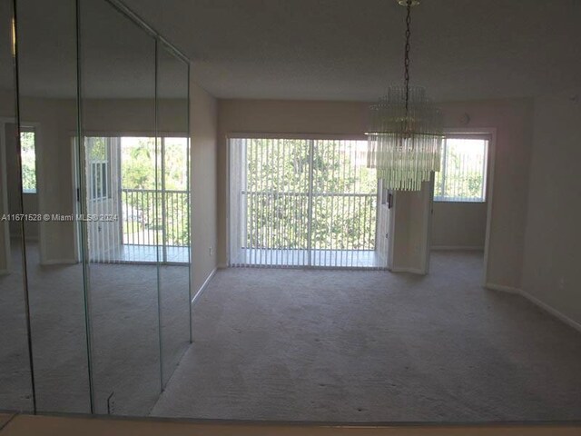 9511 Weldon Cir Unit G402, Tamarac, FL 33321 - unfurnished dining area with carpet floors, a chandelier, and baseboards