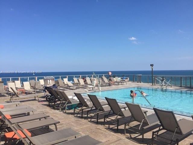 view of pool with a patio area and a water view