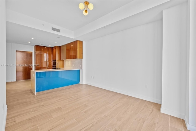 kitchen with kitchen peninsula, light wood-type flooring, and a breakfast bar area