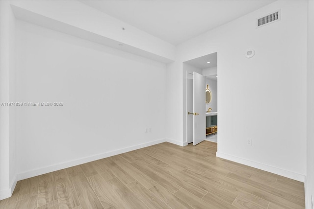 unfurnished room with light wood-type flooring