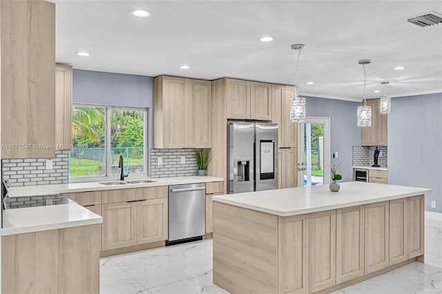 kitchen featuring sink, plenty of natural light, stainless steel appliances, a kitchen island, and light brown cabinets