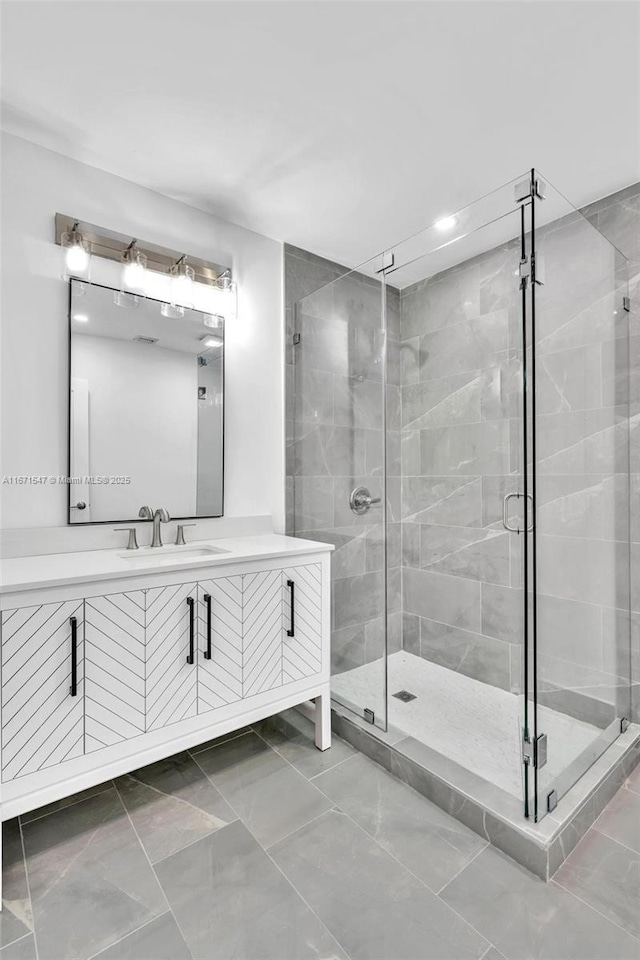 bathroom with a shower with door and vanity