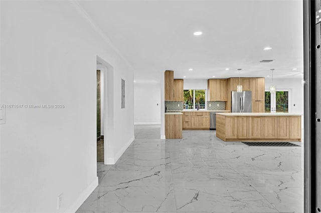 kitchen featuring light brown cabinetry, hanging light fixtures, backsplash, and stainless steel appliances