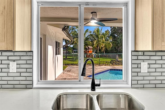 interior details featuring ceiling fan, sink, and light brown cabinets