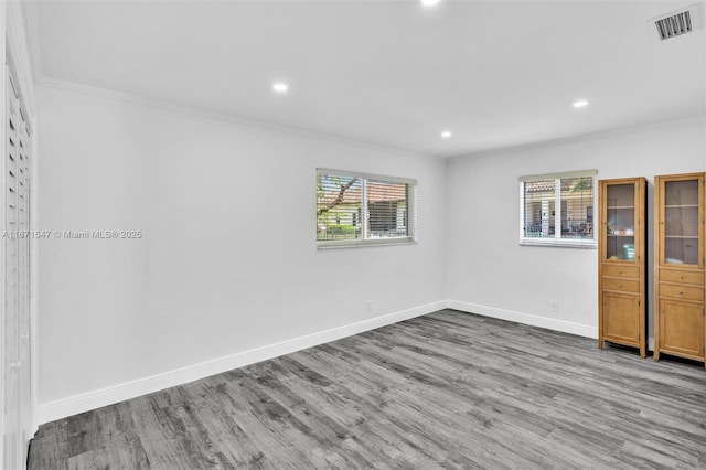 unfurnished room featuring wood-type flooring and ornamental molding