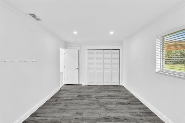 unfurnished bedroom with crown molding, dark hardwood / wood-style flooring, and a closet