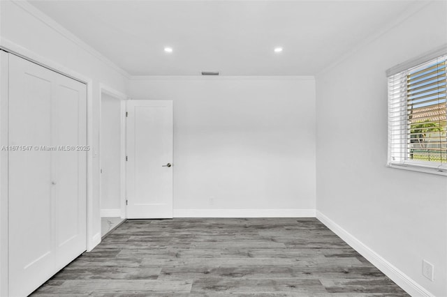 empty room with hardwood / wood-style flooring and crown molding