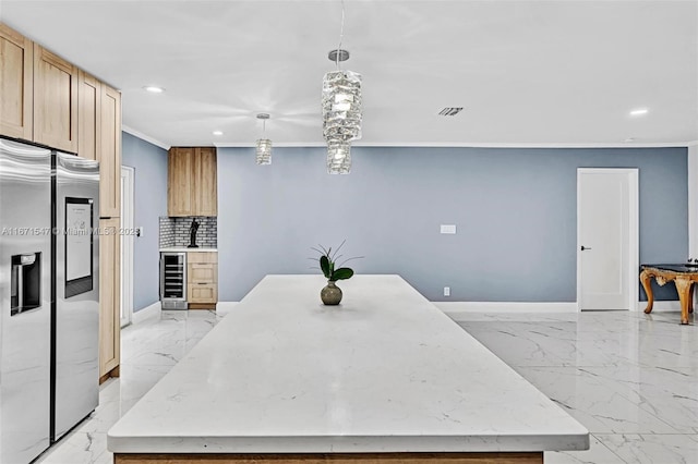 kitchen featuring hanging light fixtures, stainless steel refrigerator with ice dispenser, tasteful backsplash, ornamental molding, and beverage cooler