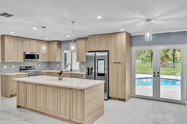 kitchen with stainless steel appliances, decorative light fixtures, and a kitchen island