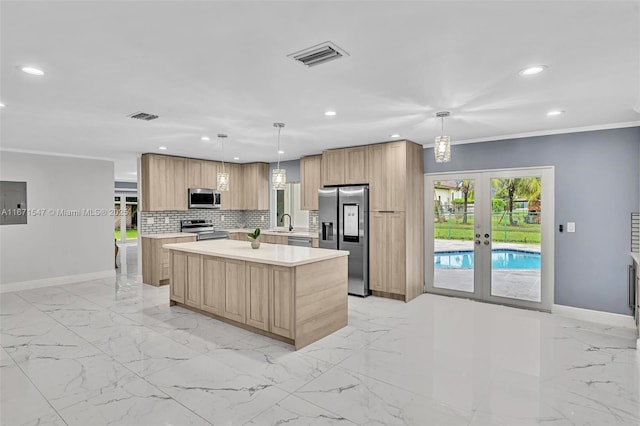 kitchen with french doors, decorative light fixtures, light brown cabinets, appliances with stainless steel finishes, and a kitchen island