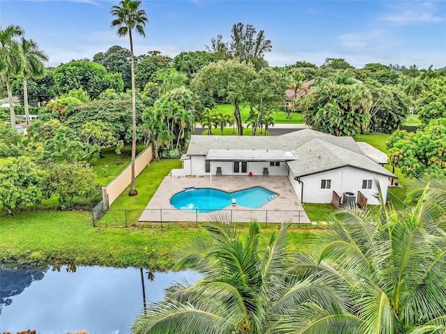 view of swimming pool with a water view, a yard, and a patio