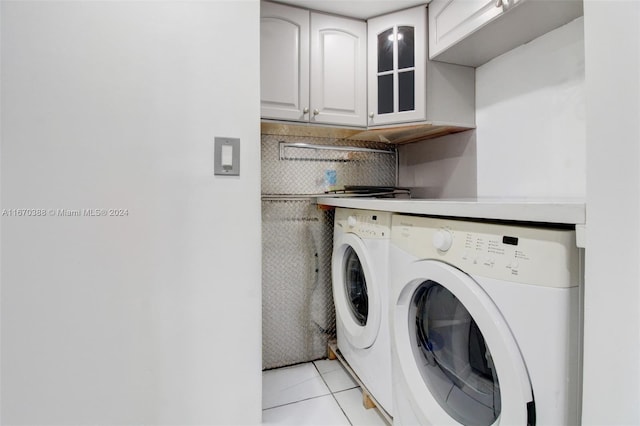 laundry room with cabinets, light tile patterned floors, and washing machine and dryer