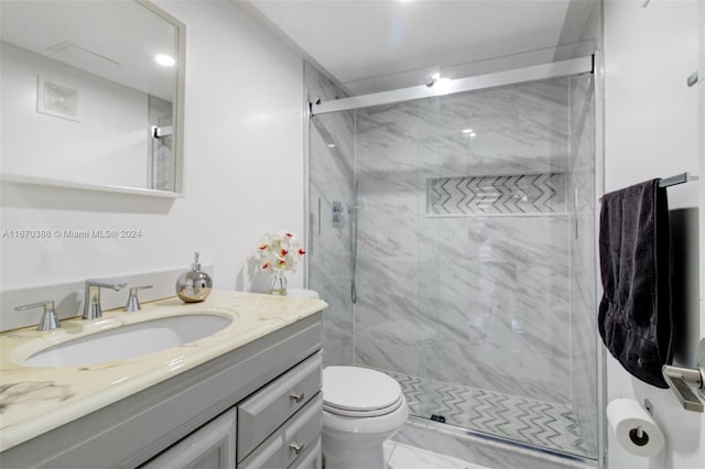 bathroom featuring vanity, toilet, and a shower with shower door