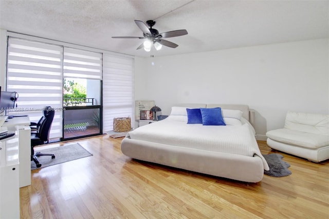 bedroom featuring light wood-type flooring, a textured ceiling, and ceiling fan