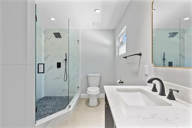 bathroom featuring tile patterned flooring, a shower with door, vanity, and toilet