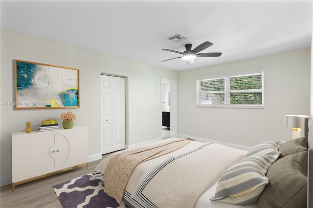 bedroom featuring ceiling fan, light hardwood / wood-style flooring, and a closet