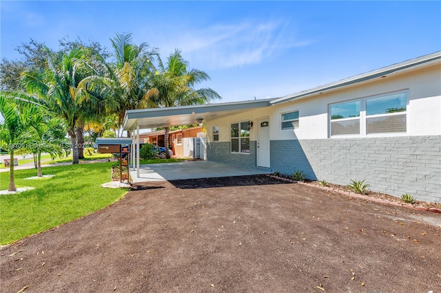 exterior space with a lawn and a carport